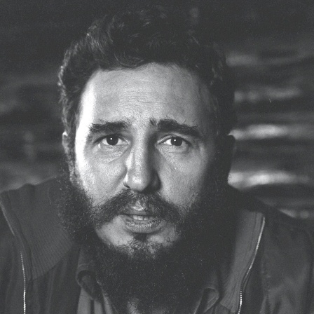 Schwarzweiß-Porträt von Fidel Castro, der ernst frontal in die Kamera blickt