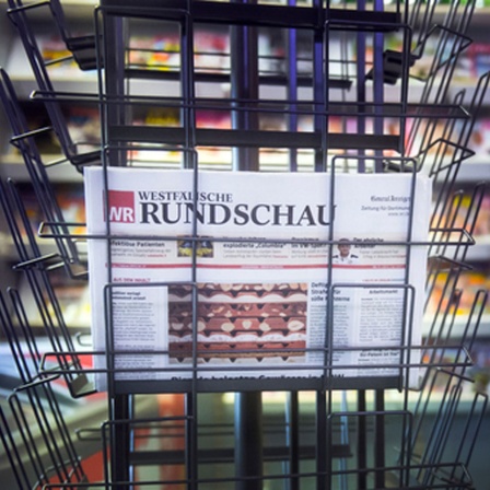 Eine letzte Ausgabe der Westfälischen Rundschau liegt in einem Zeitungsständer in einem Kiosk.