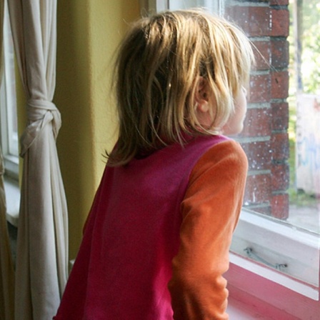 Ein Kind steht am Fenster