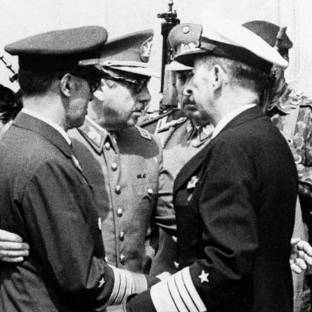 Historisches Schwarzweißfoto zeigt Militärs. Dabei Junta-Chef und späteren Diktator Augusto Pinochet einen Offizier umarmend.