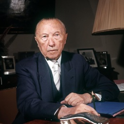 Konrad Adenauer sitzt an einem Schreibtisch.