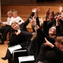 Szene aus einem Familienkonzert: Chorsänger und -sängerinnen zeigen in unterschiedlichste Richtungen