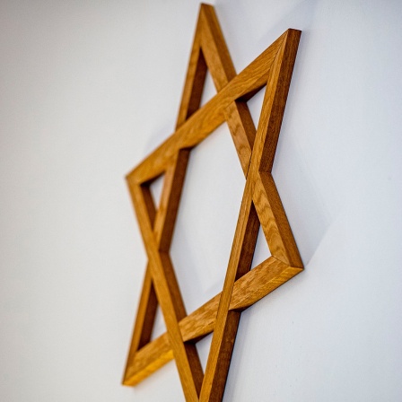 Ein Davidstern hängt an der Wand im Gebetsraum einer Synagoge. 