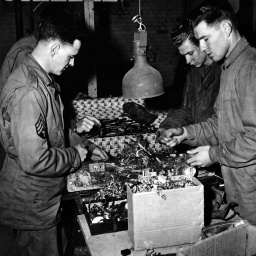 Anfang Mai 1945. Soldaten der 1. US Army untersuchen und sortieren Schmuck, Uhren und Brillen, die vom 6. DB der III. US Army bei der Freilassung des Konzentrationslagers Buchenwald gefunden wurden.