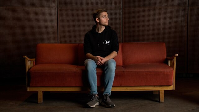 Der YouTuber Philipp Mickenbecker sitzt auf einem Sofa.