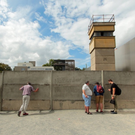 Gedenkstätte Bernauer Straße an der ehemaligen Mauer in Berlin, Deutschland: Besucher betrachten den Wachturm und Todesstreifen.