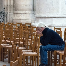 Nachdenklicher Mann sitzt in einer leeren Kirche