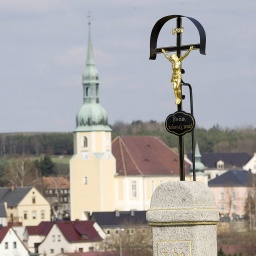 Das Dorf Crostwitz bei Kamenz mit einem Jesuskreuz und den Blick auf die Dorfmitte und die Pfarrkirche. 