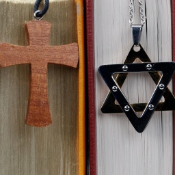 Religiöse Symbole: Christliches Kreuz, Davidstern und Hand von Fatima stehen für Christentum, Islam und Judentum