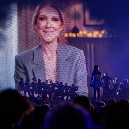 Mit einer Videoeinspielung grüßt Celine Dion am 13.05.2025 die Besucher des ersten Halbfinales des 69. Eurovision Song Contest in der Arena St. Jakobshalle. 