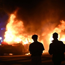 enschen sehen zu, wie Autos auf Ramels Vag in Rosengard, Malmö, nach einem Aufstand in den frühen Morgenstunden brennen, 04.09.2023. 