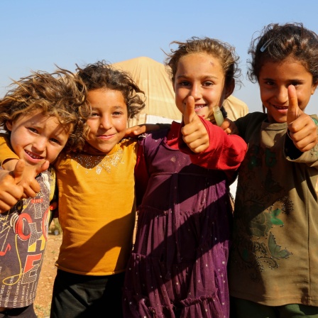 4 Kinder im syrischen Flüchtlingslager Idlib halten ihre Daumen nach oben.
