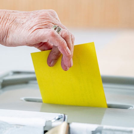Eine Wählerin wirft ihren Wahlzettel in die Wahlurne