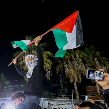 People celebrate along a street at Deir el-Balah in the central Gaza Strip, on January 15, 2025