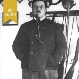 Ludwig Thoma mit einer Pfeife im Mund vor Jagdgewehren | Bild: BR Historisches Archiv, Heinrich Stuckert