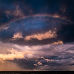 Dramatischer Himmel: Sturmwolken und ein Regenbogen.