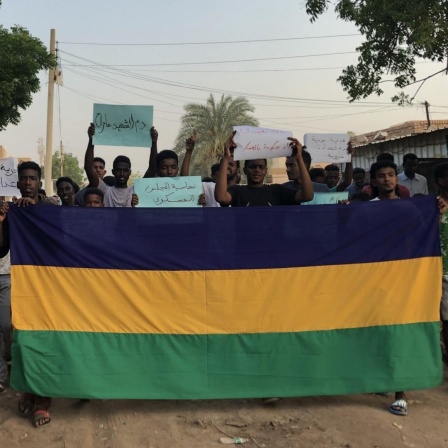 Demonstrierende im Sudan halten Schilder hoch