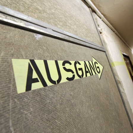 Ein Hinweisschild weist den Weg aus einem ehemaligen Luftschutzbunker.
