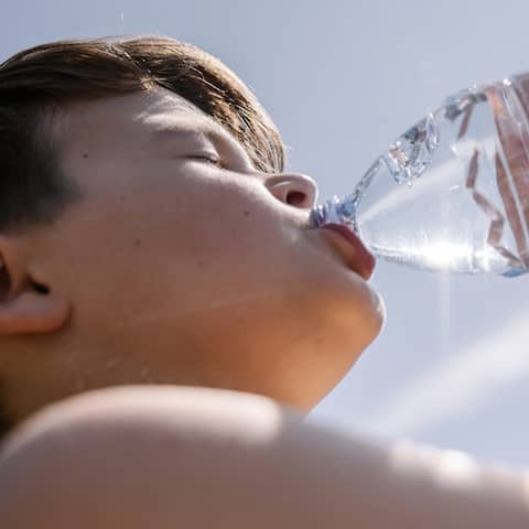 Ein Junge trinkt bei Hitze Wasser aus einer Flasche (Bild: picture alliance)