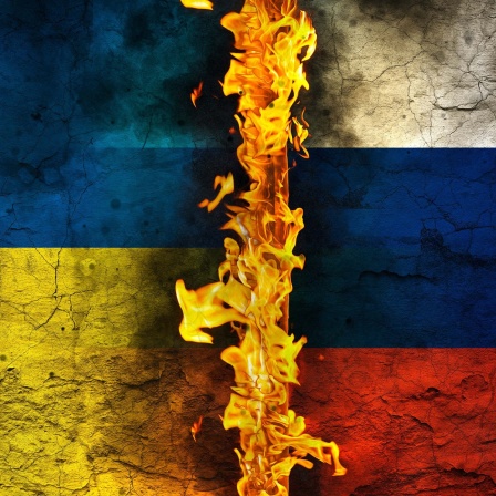Symbolbild: Feuer zwischen der ukrainischen und russischen Flagge