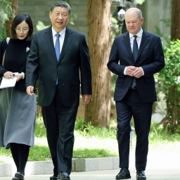 Der chinesische Präsident Xi Jinping (links) und Bundeskanzler Olaf Scholz (rechts) gehen am Rande ihres Treffens in Peking zusammen.