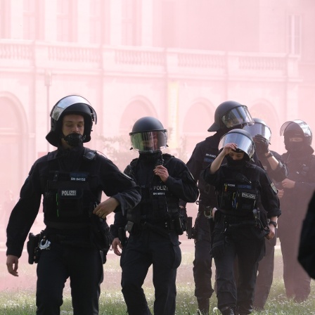 Polizisten stehen im Pyronebel bei einer linken Demonstration.