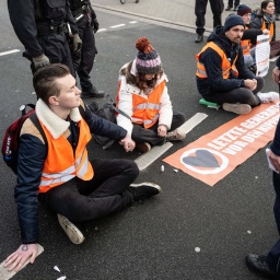 Klimaaktivisten der Gruppe "Letzte Generation" haben ihre Hände zusammengeklebt, um eine Hauptverkehrsstraße zu blockieren.