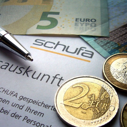 Geldscheine, Münzen, Kugelschreiber auf Schufa-Bonitätsauskunft