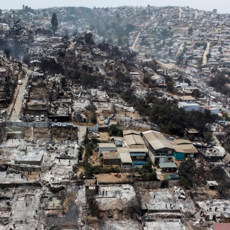 Einheimische arbeiten zwischen Trümmer von ausgebrannten Häusern, nachdem Waldbrände ihr Viertel in Vina del Mar zerstört haben.