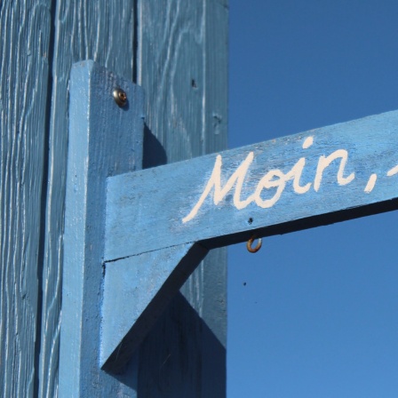 Moin Moin auf einem blauen Schild.