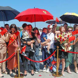 Familienangehörige von Soldaten in einem Hafen in China bei einer Begrüßungszeremonie. Das Schiff kehrt von einem Freundschaftsbesuch in Kiribati zurück.
      