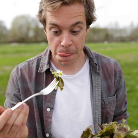 Checker Tobi hat einen Salatkopf in der Hand und beißt in ein Salatblatt. | Bild: Megaherz