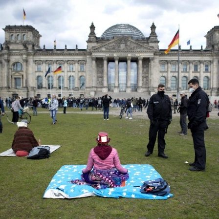 Polizisten fordern eine Frau auf den Platz zu verlassen bei einer Kundgebung gegen die Coronamassnahmen, auch Hygienedemo genannt, vor dem Deutschen Reichstag.