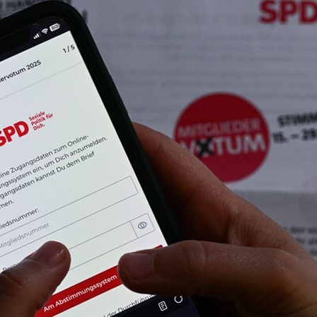 Ein SPD-Mitglied stimmt mit seinem Smartphone beim Mitgliedervotum der Partei über den ausgehandelten Koalitionsvertrag ab.