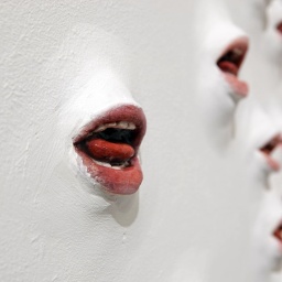 Das Bild zeigt die Kunst-Installation &#034;Die Wände werden sprechen&#034;, modellierte Münder scheinen aus einer weißen Wand heraus zu sprechen
