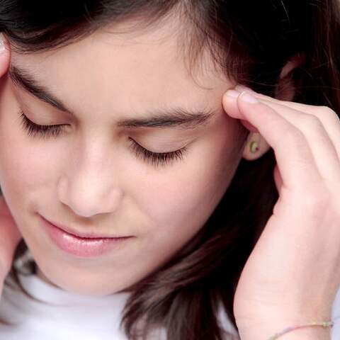 Ein Teenagermädchen mit Kopfschmerzen