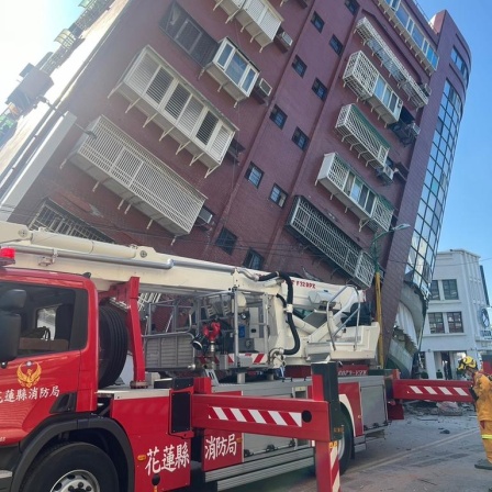 Ein Feuerwehrauto steht vor einem zur Seite gekippten Haus in Taipei.