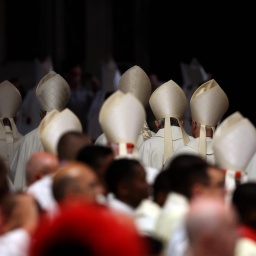 Kardinäle verlassen die Basilica nach einer Messe. Die Kardinälshüte sind von hinten zu sehen.