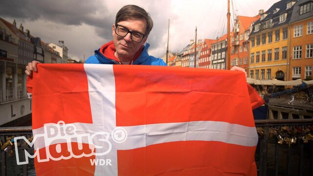 Ralph mit einer Dänemarkflagge in der Hand und die Maus steht daneben.