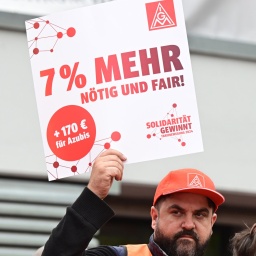 Arbeiter demonstrieren für die Metall- und Elektroindustrie mit Transparenten für eine Forderung von 7 Prozent mehr Lohn.