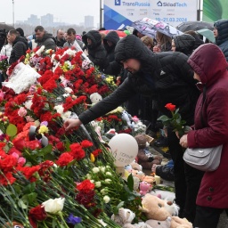 Menschen legen in Gedenken an die Opfer des Anschlags Blumen vor der Crocus City Hall nahe Moskau nieder.