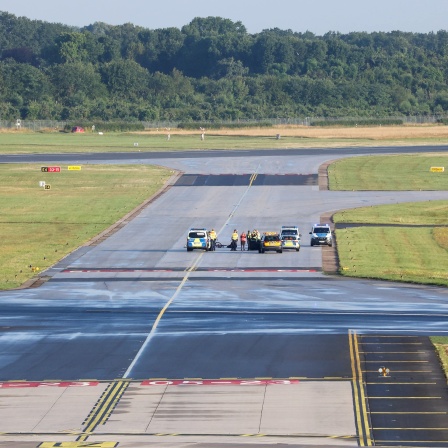 Landebahn am Hamburger Flughafen mit Polizeiautos.