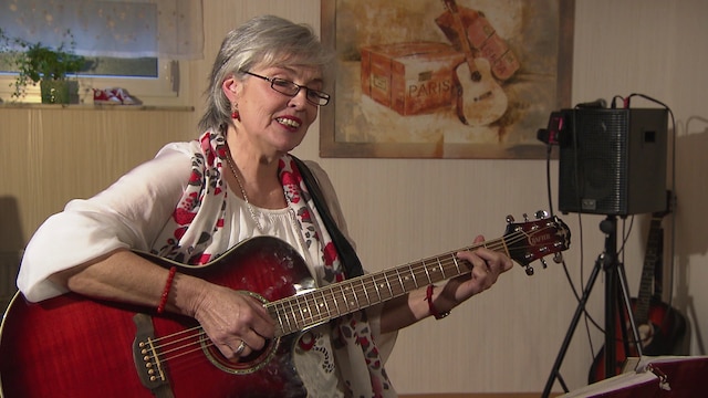 Foto: Eine ältere Frau mit Gitarre