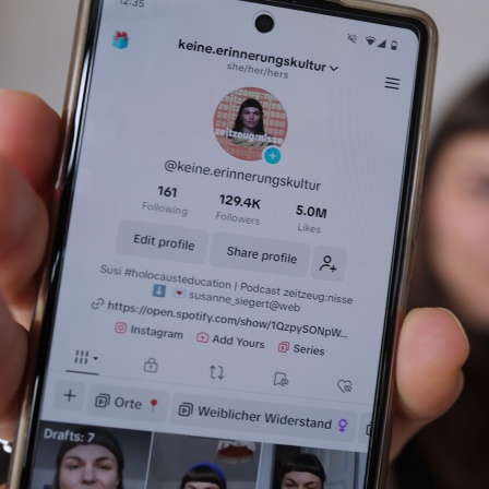 Susanne Siegert, Content Creator, hält ein Handy mit der Startseite ihres TikTok-Accounts in der Hand. Archivbild: 18.11.2023