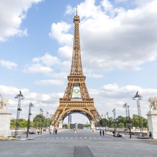 Am Eiffelturm in Paris hängt das Logo der Olympischen Spiele mit den Olympischen Ringen.