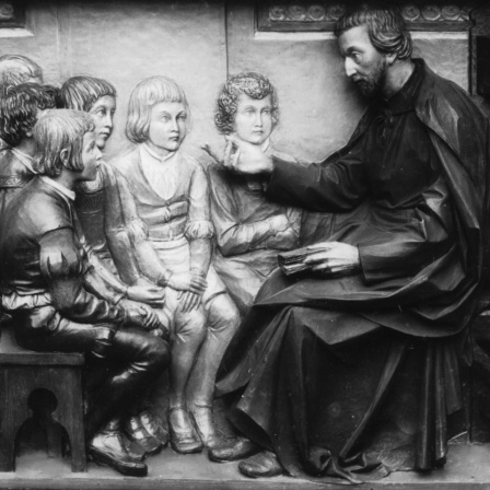 Petrus Canisius als Jugendlehrer. Er war erster deutscher Jesuit, 1521-1597. Ein Relief von Canisius in Augsburg.