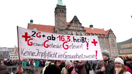 Menschen protestieren in Chemnitz mit einem Transparent gegen die Impfpflicht im Gesundheitswesen.
