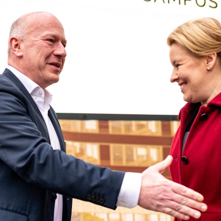 Ein glatzköpfiger Mann im blauen Anzug schaut an einer Frau mit blonden Haaren und rotem Mantel vorbei. Szene zeigt Kai Wegner (CDU) und Franziska Giffey am 20.02.2023 zu Beginn von Sondierungsgesprächen