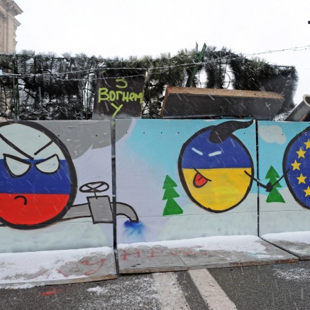 Ukraine-Smiley hält EU-Smiley an der Hand und streckt Russland-Smiley die Zunge heraus: Barrikade auf dem Kiewer Unabhängigkeitsplatz am 7. Dezember 2013 mit Zeichnungen, die den Beitritt der Ukraine zu Europa auf Kosten Russlands und seiner Gasdiplomatie darstellen