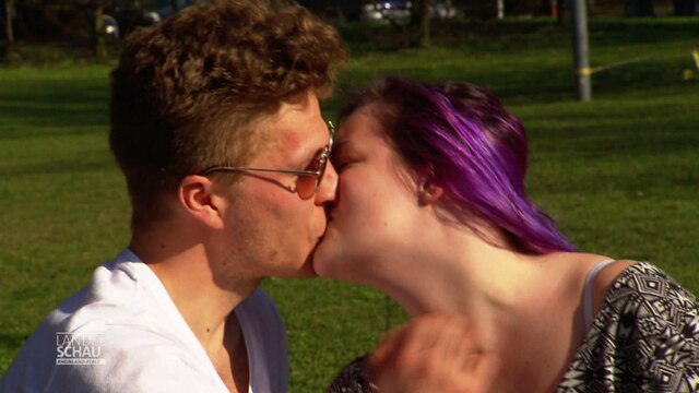 Ein Pärchen küsst sich im Park